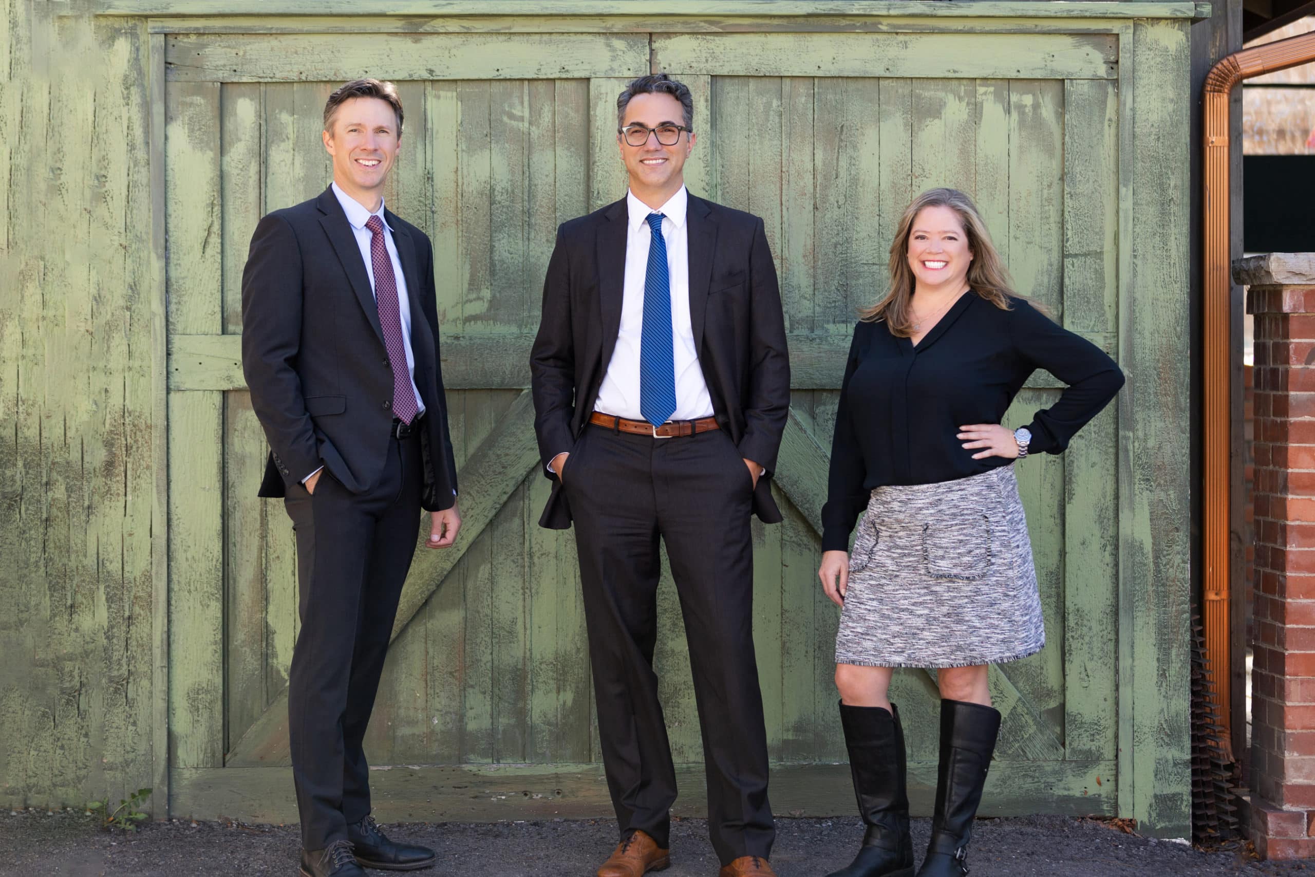 HSD partners standing in front of a green door smiling